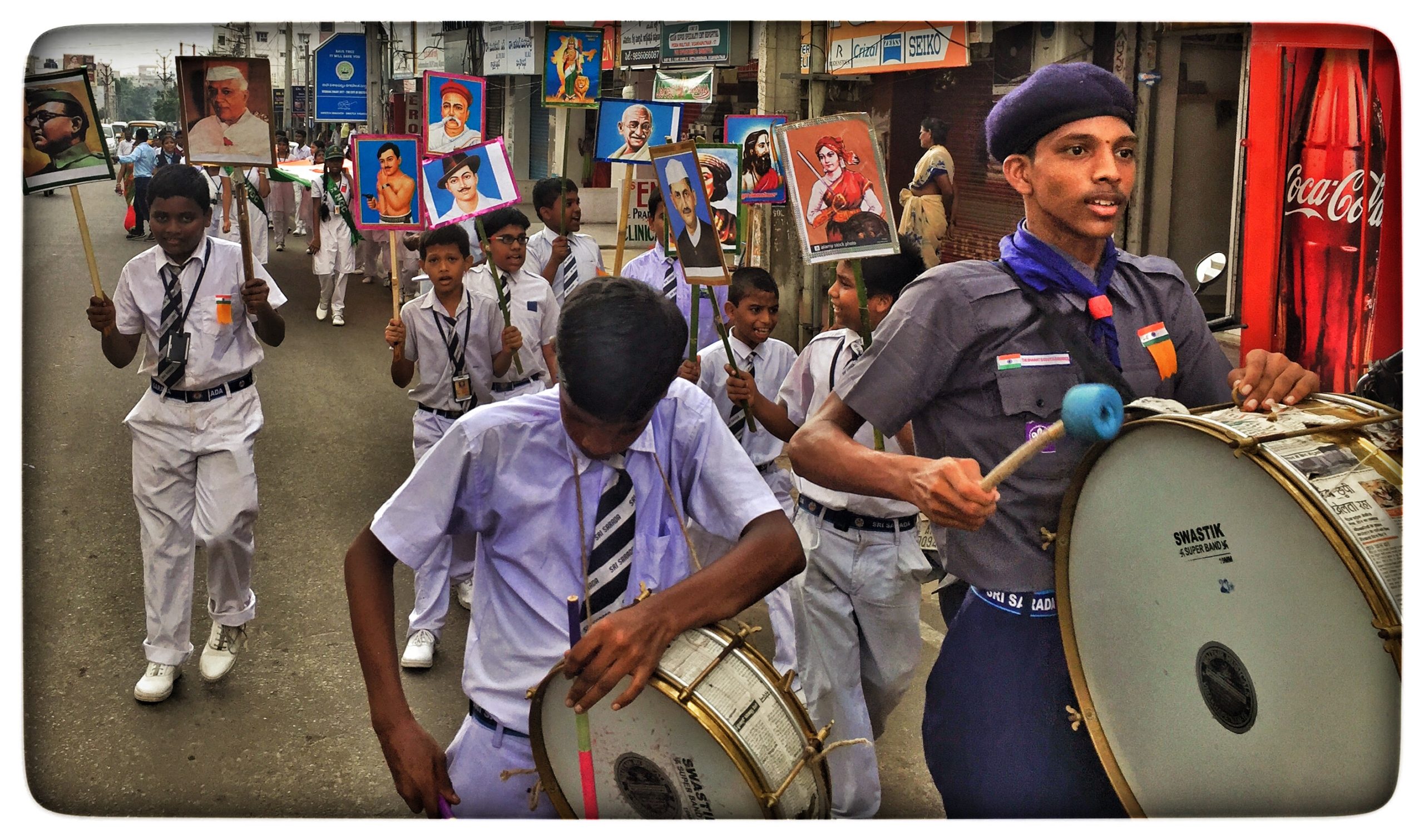 School children in uniform participating in the Independence Day morning rounds in Visakhapatnam, walking in unison with Indian flags held high."